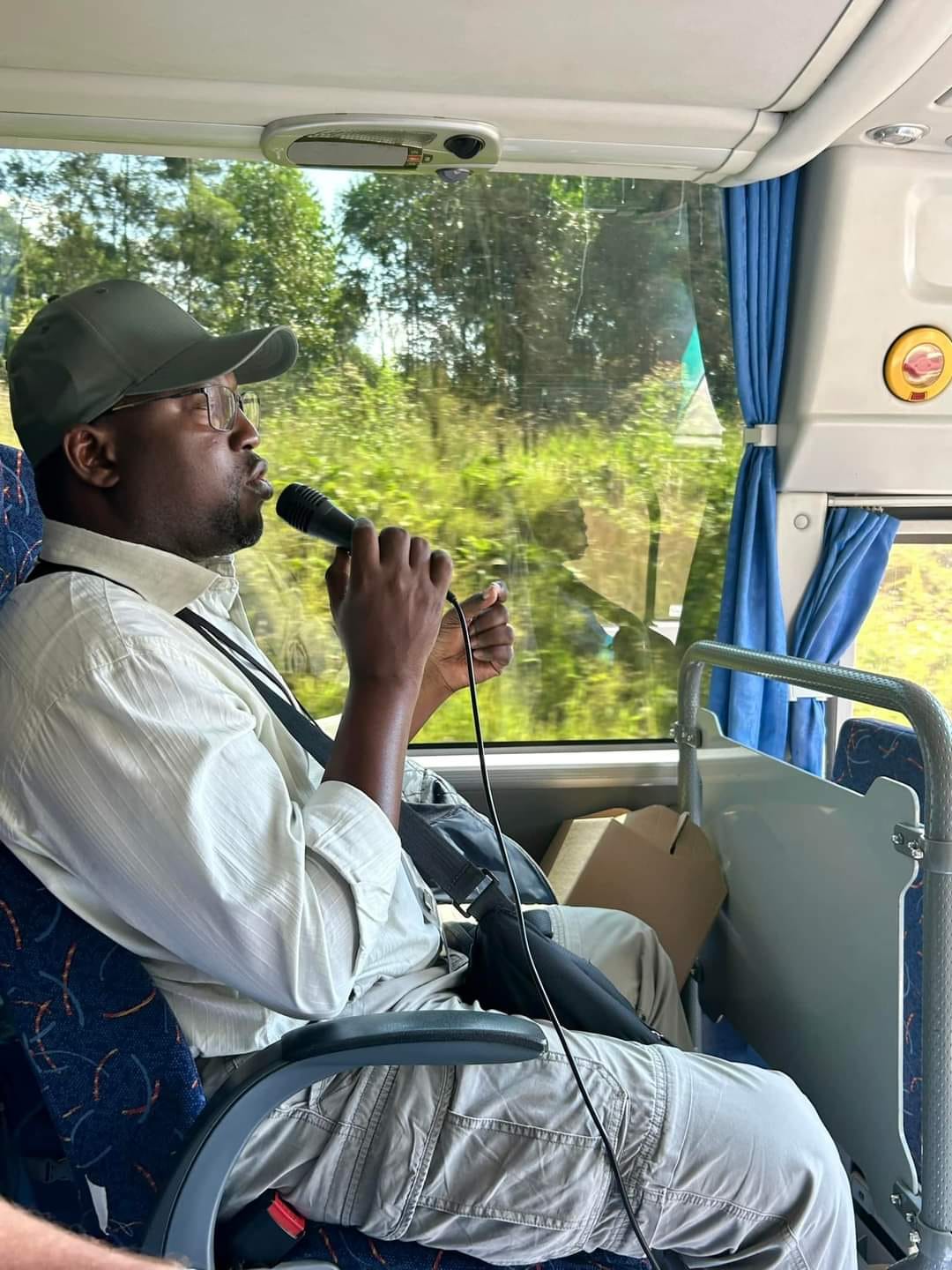 Professional tour guide speaking to guests on a coach